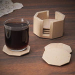 A set of marble star-shaped coasters with one holder, displayed on a wooden surface, with one coaster being used to hold a glass of liquid.