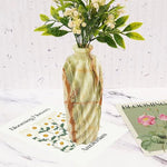 Marble-patterned vase with flowers on a textured surface with 'Blooming' cards.