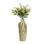 Decorative vase with marble pattern containing artificial flowers on a white background