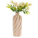 Beige textured vase with greenery on a white background