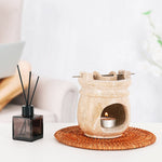 Aroma lamp with a candle and diffuser on a woven coaster.