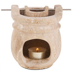 Stone-colored wax warmer with a lit tealight candle on a white background