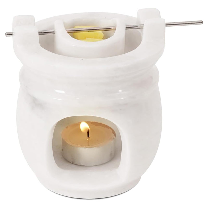 White ceramic wax warmer with a lit tealight candle on a white background