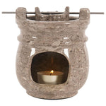 Stone-textured oil burner with a lit candle inside on a white background