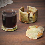 A set of marble star-shaped coasters with one holder, displayed on a wooden surface, with one coaster being used to hold a glass of liquid.